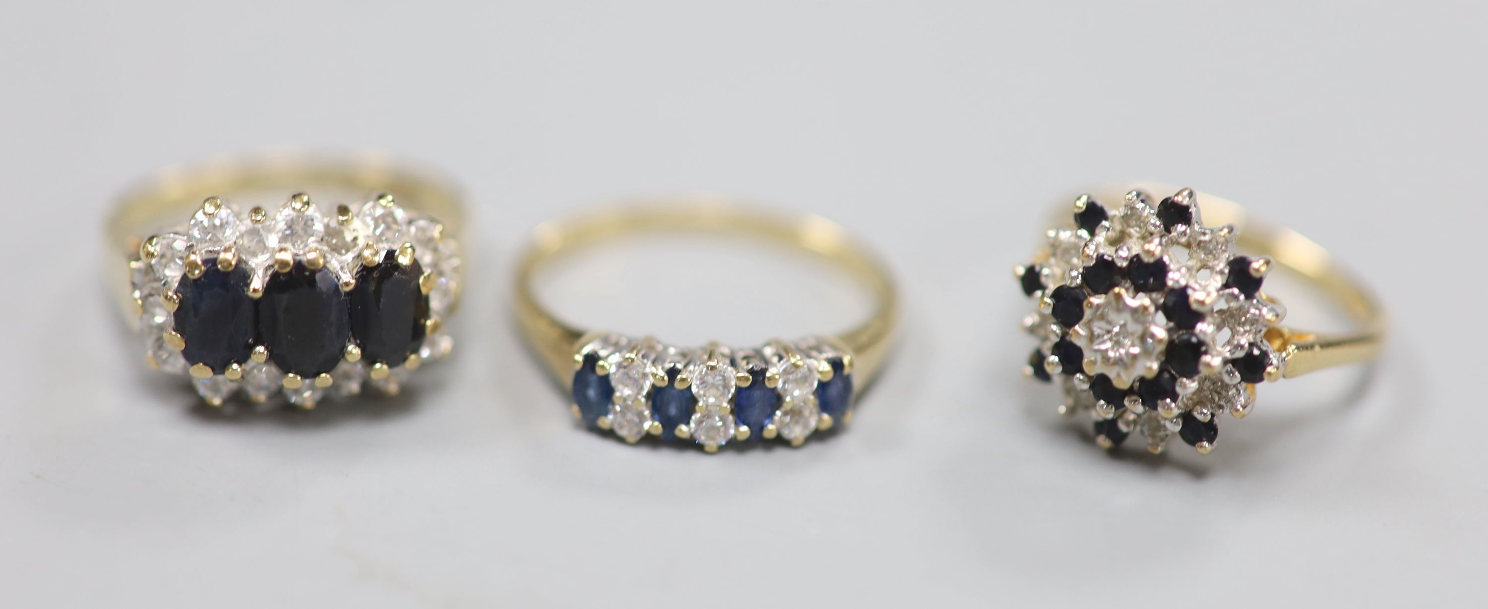 Three assorted modern 9ct gold and gem set dress rings, including one sapphire and diamond, gross weight 7.3 grams.